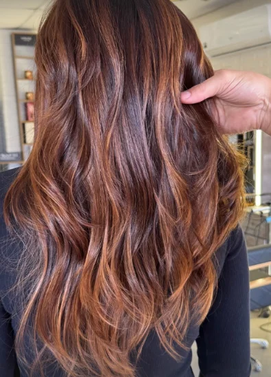 Cliente de cabelo longo com mechas em tom caramelo